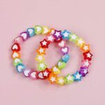 Multicolored star and heart bracelet on pink background