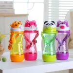 Children's bottle 450 ml in the shape of a 3D colored animal on a table in front of a window