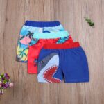 Colorful children's cartoon beach shorts with wooden background