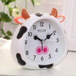 Cow-shaped children's alarm clock on white furniture