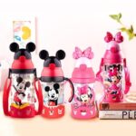 Red and pink children's Mickey bottle on a table with a white wall