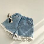 Girl's lace denim shorts with sunglasses on white background