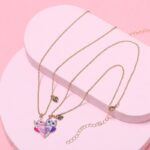 Girlfriend heart necklace with silver chain on pink background