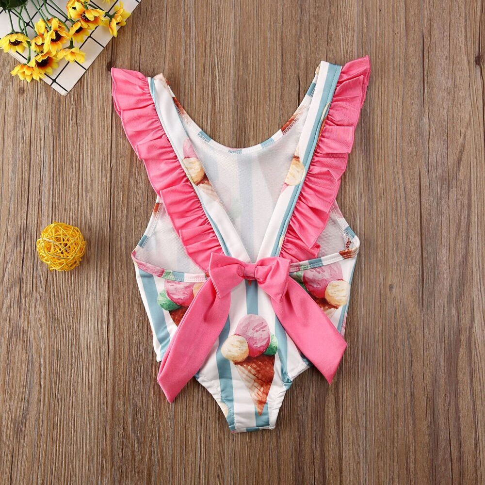 Girl's one-piece swimsuit with ice print and wood background