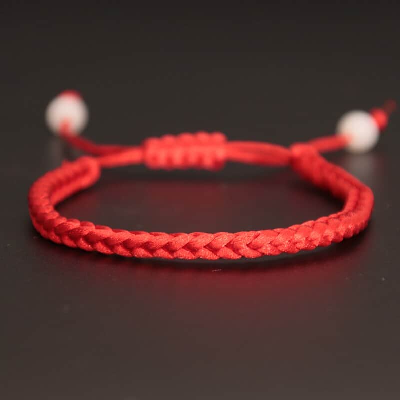Bracelet in hand-woven red rope on black background