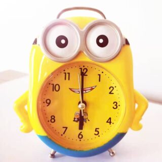 Minion-shaped children's alarm clock on white background