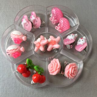 Set of 7 clip-on earrings for children in pink, in a transparent divisor with white background