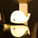 LED bedside lamp in the shape of a luminous whale with black eyes