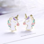 White and colored girl's unicorn ear stud on white paper