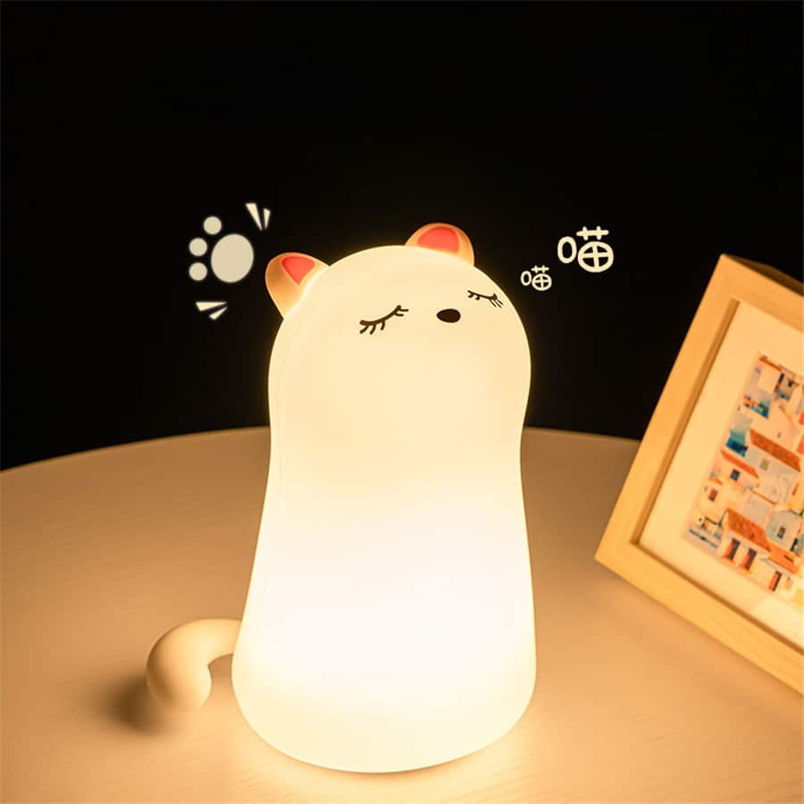 Silicone cat nightlight with pink ears on wooden table with molding