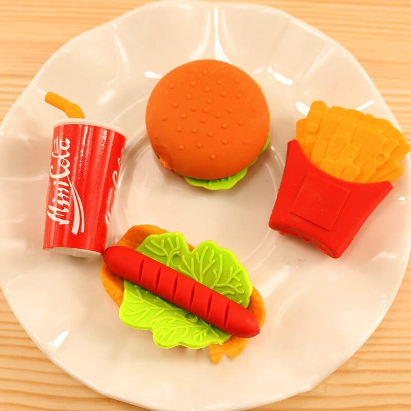 3 pieces of gum in the shape of children's food in a white plate on a wooden table