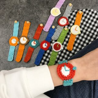 Knitted wool bracelet in the shape of a colorful watch on a woman's wrist with gray background