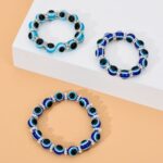 Elastic glass bead bracelet for kids blue and black on white and orange shelf