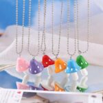 Resin necklace with colored mushroom pendant with white dots and silver chain
