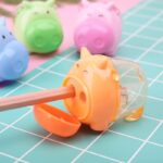 Mini hippopotamus sharpener in orange, blue, green and pink, on a blue checkered table