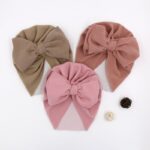 Turban with big bow for children, pink and brown on a white table