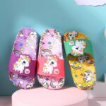 Colorful unicorn rainbow flip-flops in front of a blue wall
