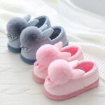 Pink and grey bunny slippers on a white blanket
