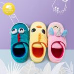 Fun animal-patterned slippers in green, yellow and pink with purple wallpaper