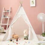 Portable white teepee tent for kids with stuffed animals inside in a pink room