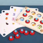 Wooden interaction game with red pieces and papers with numbers and vegetables
