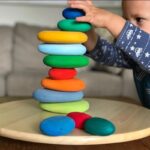 colorful stone stacking toys for children on a wooden dish