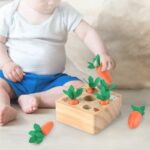 Wooden puzzle of carrot harvest with baby on white carpet