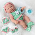 Soft doll for newborns with green and pink clothes on a white coat