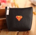 Coin purse with Superman logo in black on a wooden base