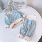 Children's blue and white striped fleece pyjama set on a white round table