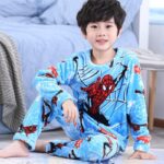 Spider-Man soft fleece pajamas for boys blue on a boy next to his bed