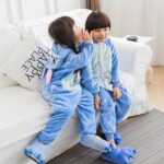 Warm cartoon pyjamas for kids blue stitch with 2 kids on a white sofa