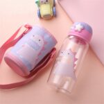 Pink children's water bottle with dinosaur design and bag