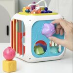 Cube-shaped early-learning game with several sides and objects of different shapes and textures for babies