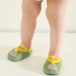a baby is standing with only its legs visible, wearing small, soft, breathable green booties
