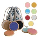 set of 14 round, colorful pieces with different textures placed next to a fabric storage bag