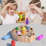 two young children sitting at a table enjoying catching colorful animals with a magnetized wooden fishing rod