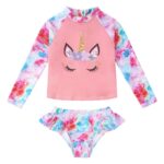 two-piece swimsuit for girls with a long-sleeved top featuring a unicorn's head, and panties with ruffles on the sides. The swimsuit is pink