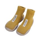 pair of yellow socks with a white label on top, presented on a white background
