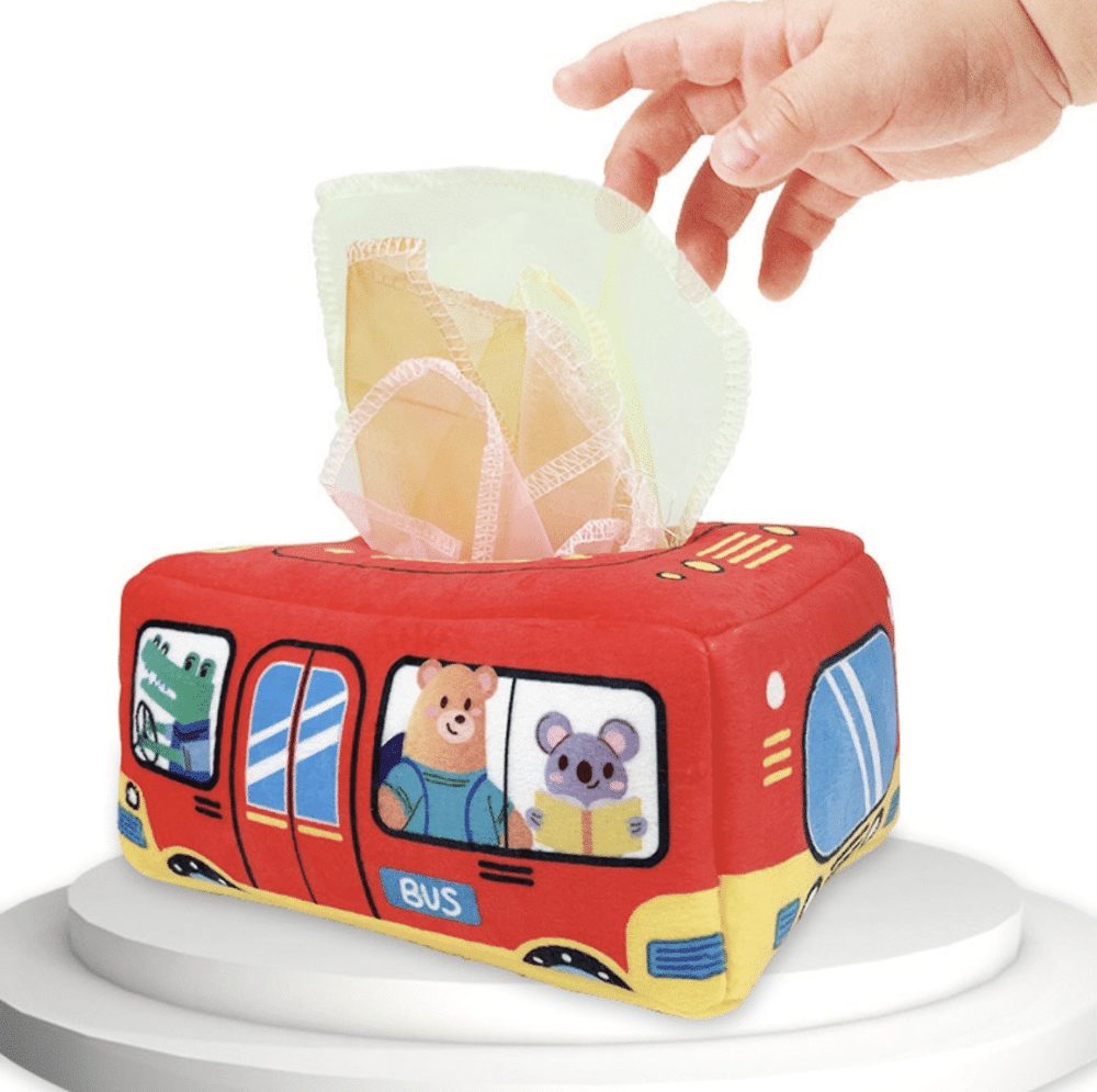 red tissue box in the shape of a bus with animals inside, into which a baby puts tissues