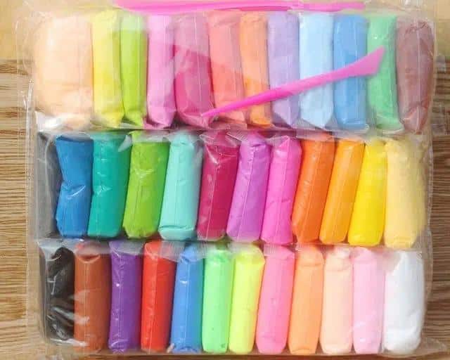 36-color polymer clay for children in a transparent bag on a wooden table