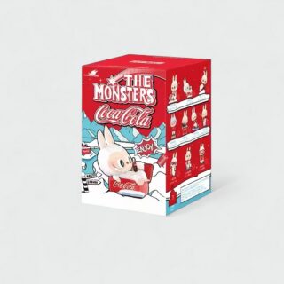 Red box with a drawing of a Labubu-style monster lying down drinking a Coke, set against a snowy mountain scene. The box is shown on a beige-colored background.